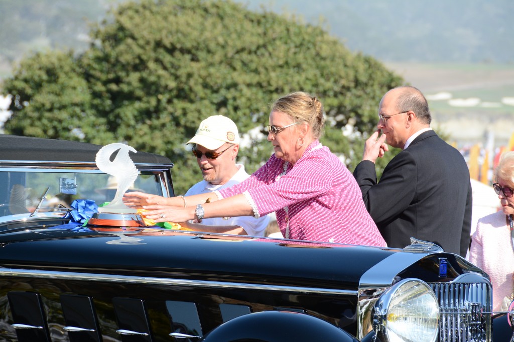 Concours chairman Sandra Button carefully sets one of the trophies on the Patterson's stunning Best of Show Winning Isotta. She's the boss, she can touch...